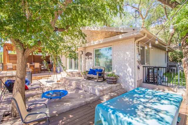 a view of a patio with table and chairs near a large tree