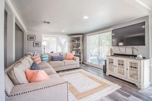 a living room with furniture a flat screen tv and a window