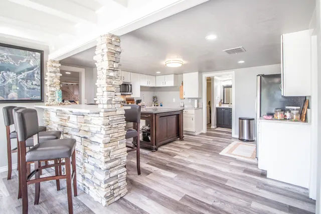 a kitchen with stainless steel appliances kitchen island granite countertop a refrigerator and a stove top oven