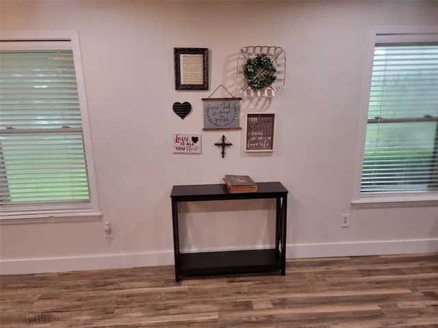 a living room with a wooden floor and a window