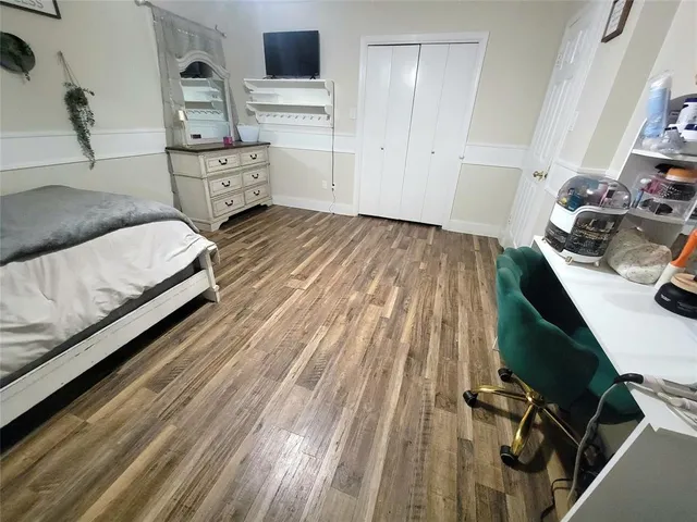 a bedroom with a bed and a flat tv screen on the dresser