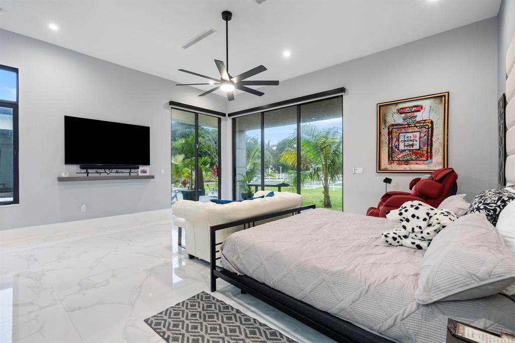 13500 Stirling Road Southwest Ranches, FL 33330 - Photo 33 of 72 a bedroom with a bed and a flat screen tv