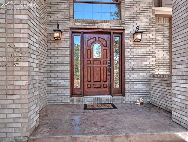 735 Winding Hills Road Monument, CO 80132 - Photo 1 of 42 Covered entry with stamped concrete porch and sidewalk