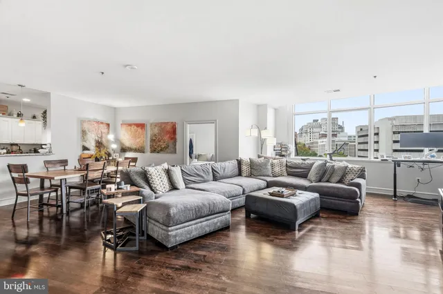 a living room with furniture wooden floor and a view of kitchen