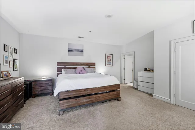 a spacious bedroom with a bed and a cabinets
