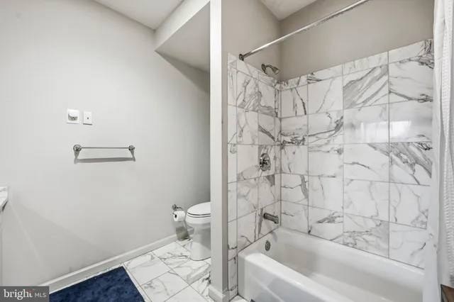 a bathroom with a toilet and a shower