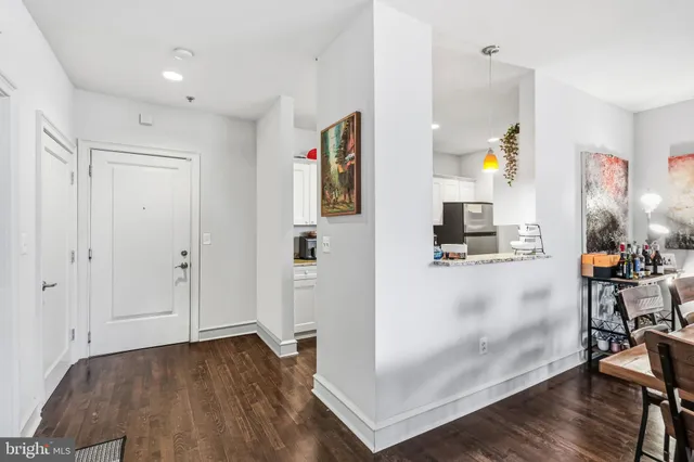a view of a hallway with wooden floor table and windows