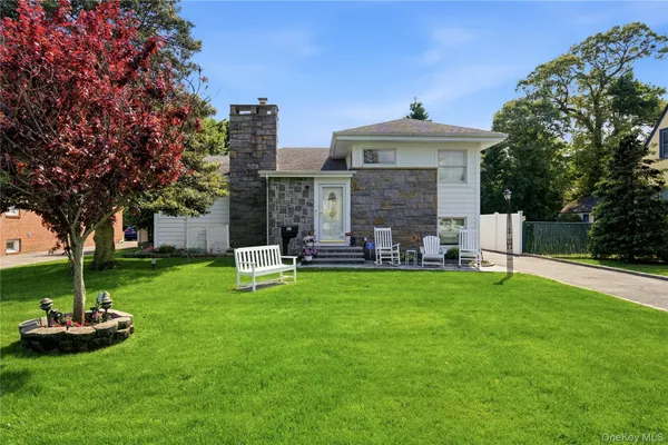 a front view of a house with garden and trees