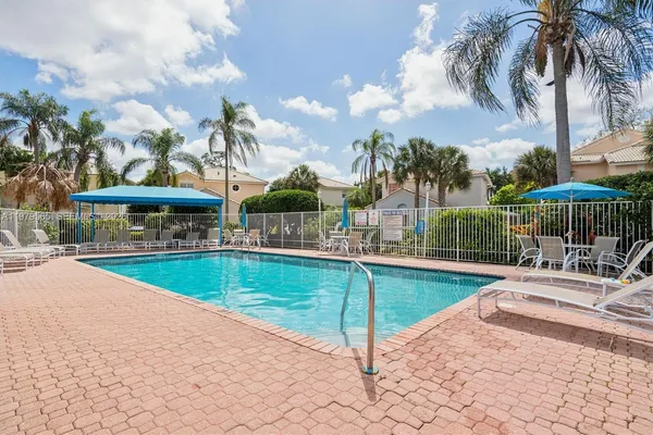 a view of a swimming pool with lawn chairs under an umbrella