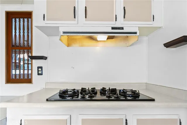 a kitchen with a sink a refrigerator and cabinets