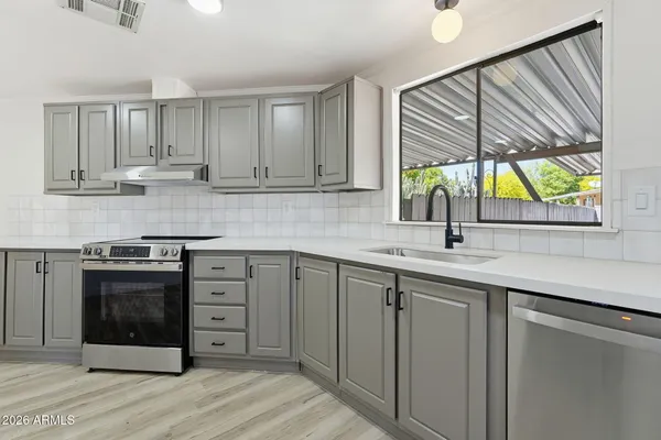 a kitchen with stainless steel appliances granite countertop a stove a sink and a microwave