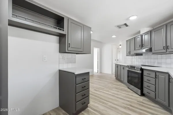 a kitchen with stainless steel appliances granite countertop a sink a stove and a refrigerator