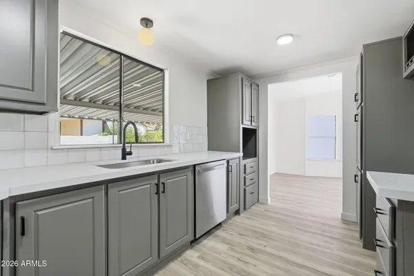 a kitchen with granite countertop cabinets stainless steel appliances a sink and a window