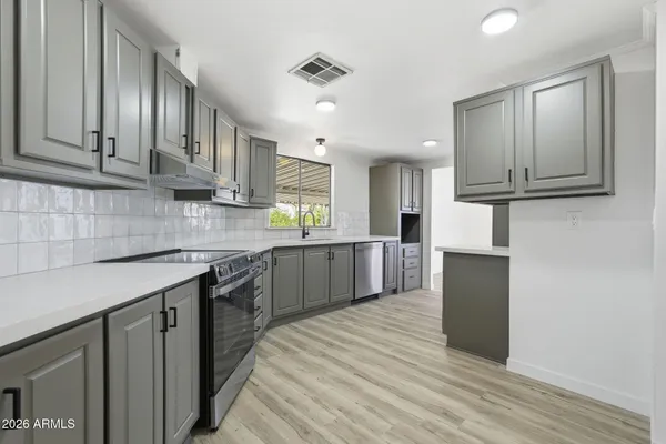 a kitchen with stainless steel appliances granite countertop a stove and a sink