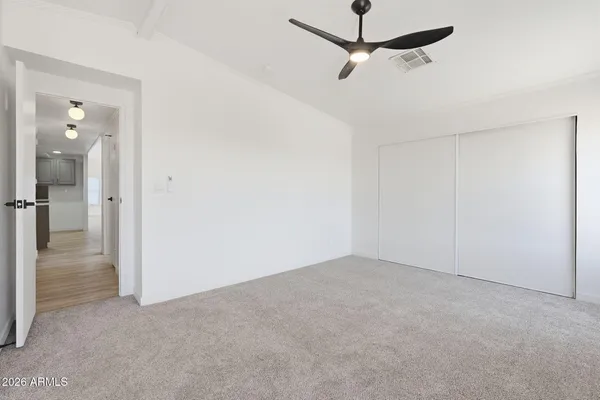 a view of a big room with windows and chandelier fan