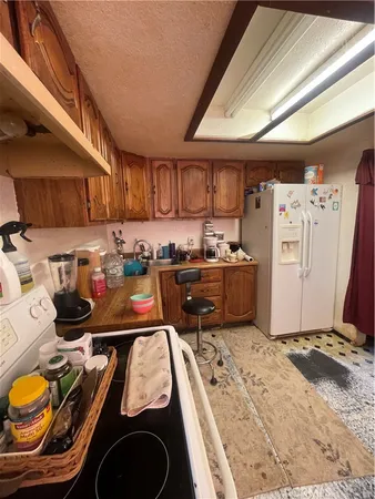 a kitchen with kitchen island granite countertop a stove refrigerator and cabinets