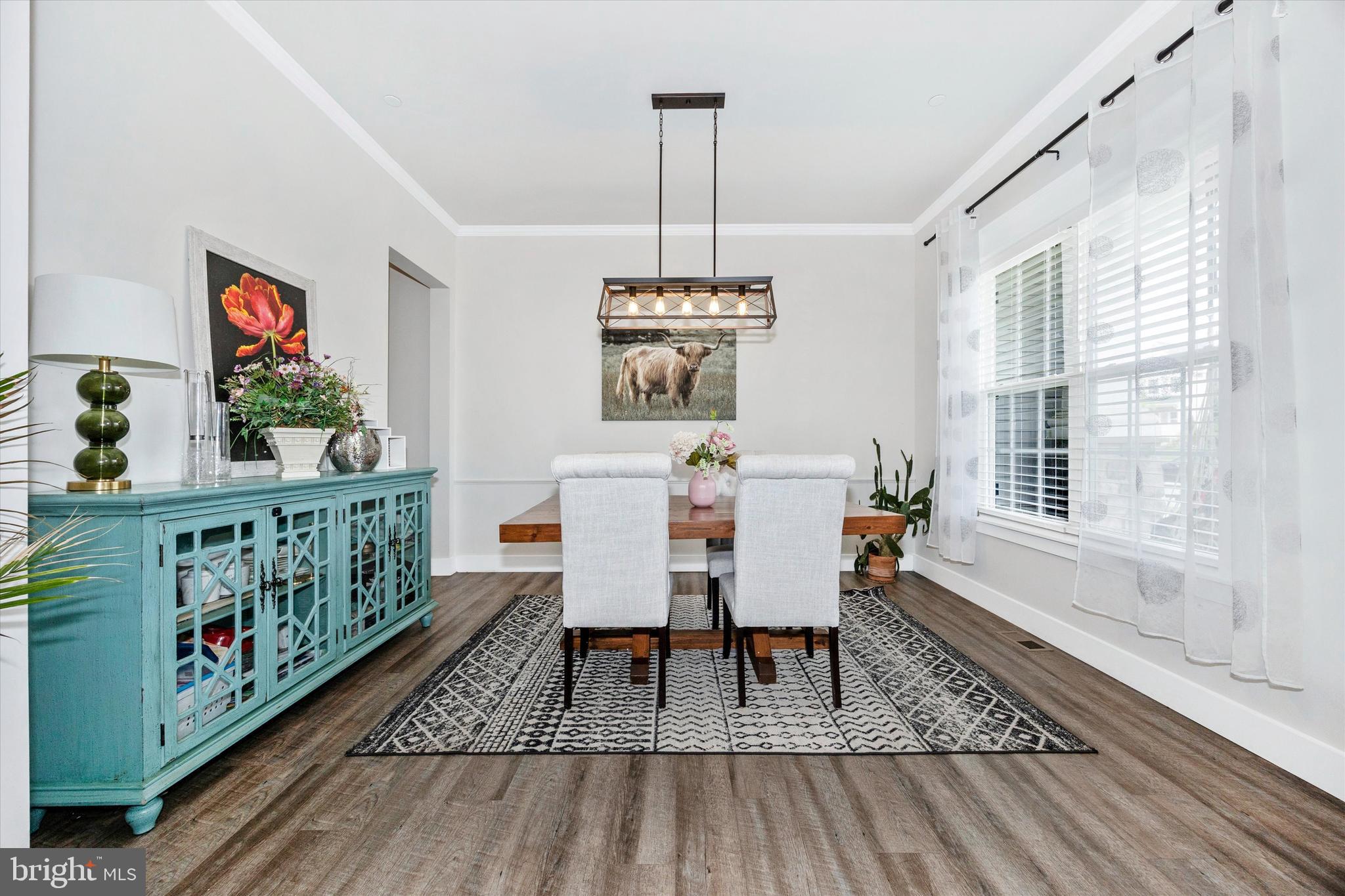 1694 Double Bank Road Frederick, MD 21702 - Photo 16 of 79 a dining room with wooden floor a chandelier a wooden table and chairs