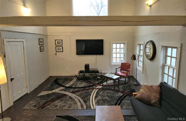 a living room with furniture a flat screen tv and a window