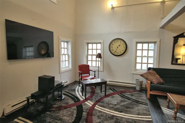 a living room with furniture a window and a flat screen tv