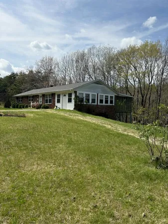 a view of a house with a yard and sitting area