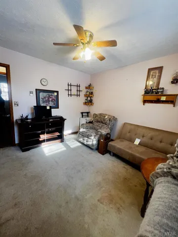 a living room with furniture and a ceiling fan