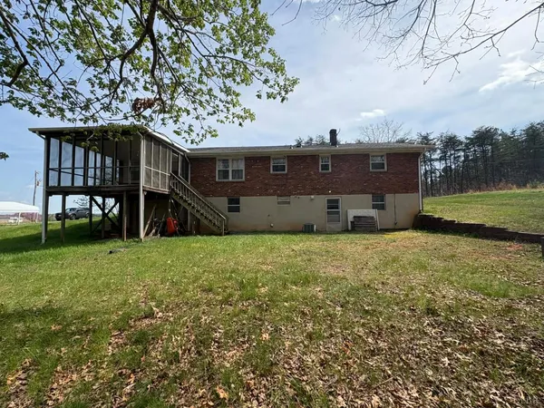 a view of a house with a yard and sitting area