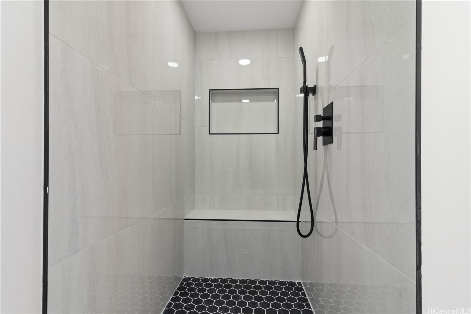 469 Ena Road, Unit 2304 Honolulu, HI 96815 - Photo 14 of 25 Expansive walk-in shower featuring a built-in bench, refined finishes, and a rare luxury touch