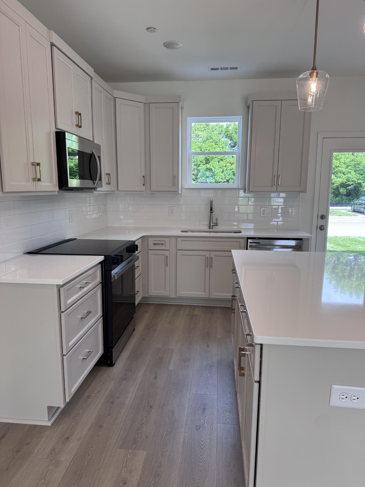 1963 Amacher Drive Spring Hill, TN 37174 - Photo 5 of 17 a kitchen with a sink a stove a microwave and cabinets