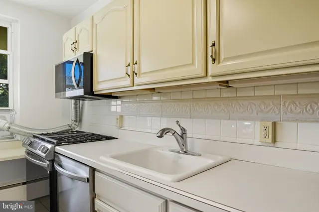 a kitchen with stainless steel appliances granite countertop a sink and a white cabinets