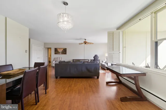 a living room with furniture a dining table and a wooden floor