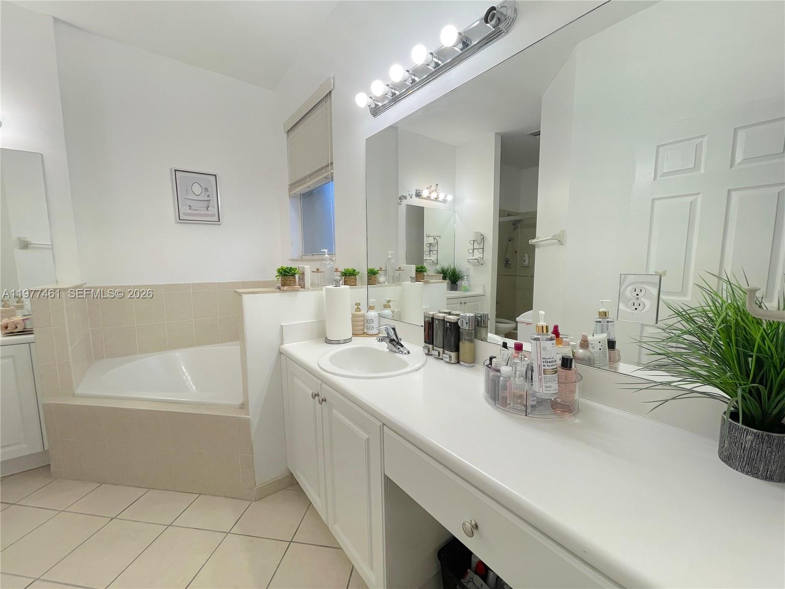 12958 Southwest 135th Street Miami, FL 33186 - Photo 11 of 14 a bathroom with a sink a tub and a mirror