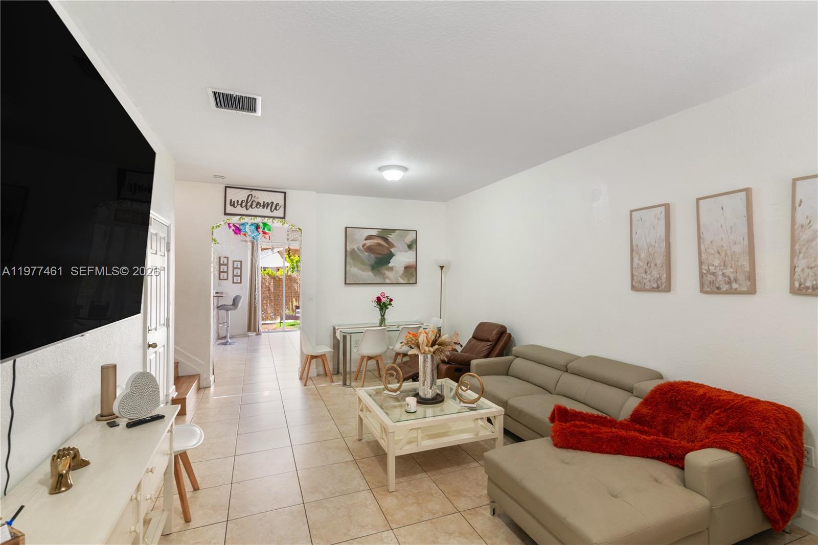 12958 Southwest 135th Street Miami, FL 33186 - Photo 5 of 14 a living room with furniture and a flat screen tv