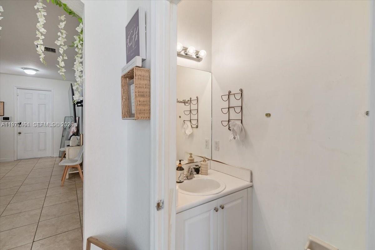 12958 Southwest 135th Street Miami, FL 33186 - Photo 8 of 14 a bathroom with a sink and mirror with shower
