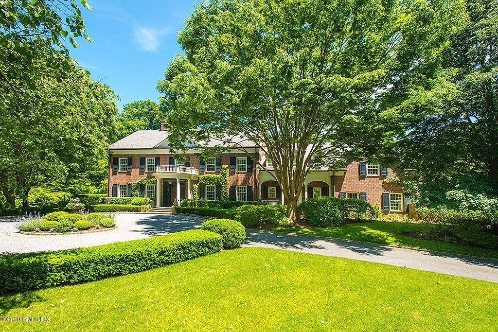 27 Midwood Road Greenwich, CT 06830 - Photo 1 of 30 a front view of a house with a yard table and chairs