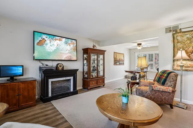 a living room with furniture a flat screen tv and a fireplace