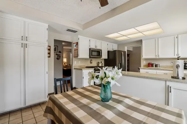 a kitchen with stainless steel appliances kitchen island granite countertop a refrigerator and a sink