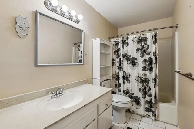 a spacious bedroom with a bed and a chandelier