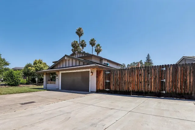 a front view of a house with a yard and fence