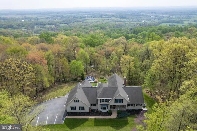 a view of a house with a big yard and large trees