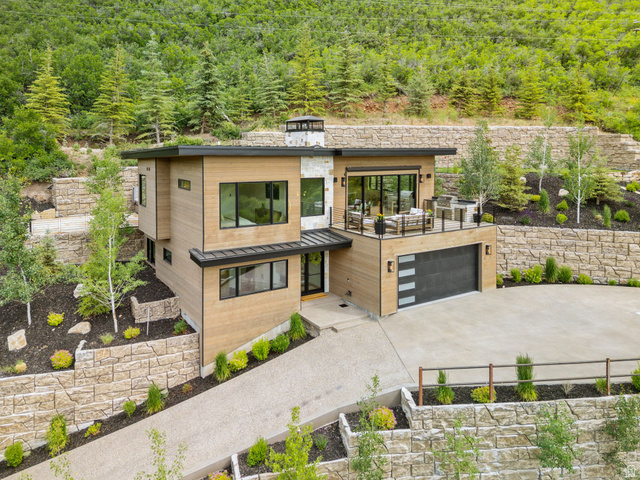 1400 Weber Wild Road Oakley, UT 84055 - Photo 4 of 55 Contemporary multi-level exterior with wood-finish siding, stone accents, black-framed windows, and a flat roofline