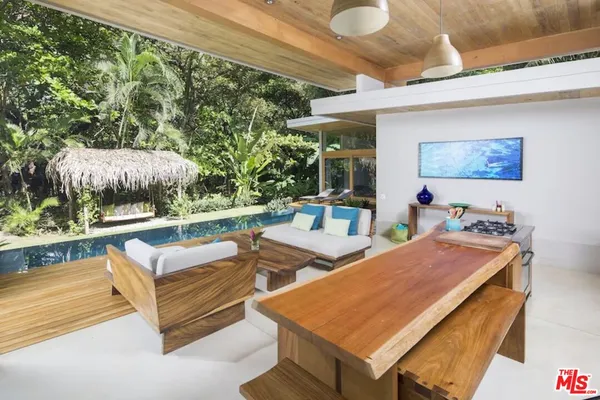 a living room with stainless steel appliances kitchen island granite countertop furniture and a large window