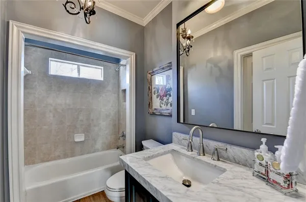 a bathroom with a granite countertop sink a toilet and shower