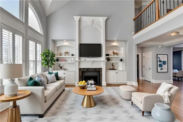 a living room with furniture a fireplace and a large window