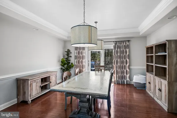 a kitchen with stainless steel appliances granite countertop a table chairs stove and cabinets