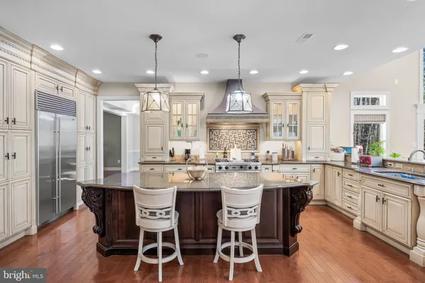 a kitchen with stainless steel appliances kitchen island granite countertop a table and chairs in it