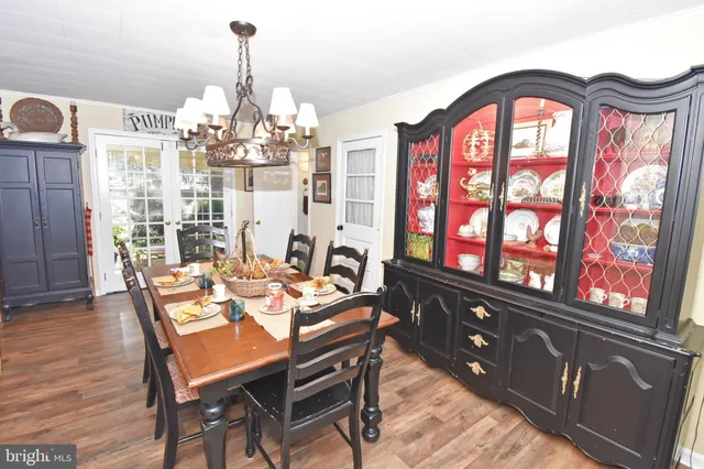 a dining room with furniture a chandelier and wooden floor