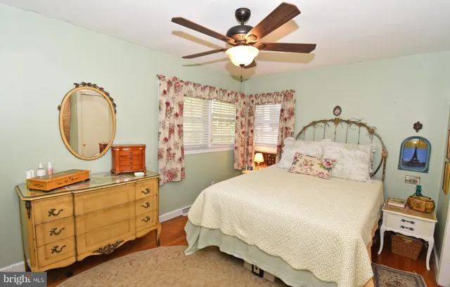 a bedroom with a bed a chandelier and a dresser
