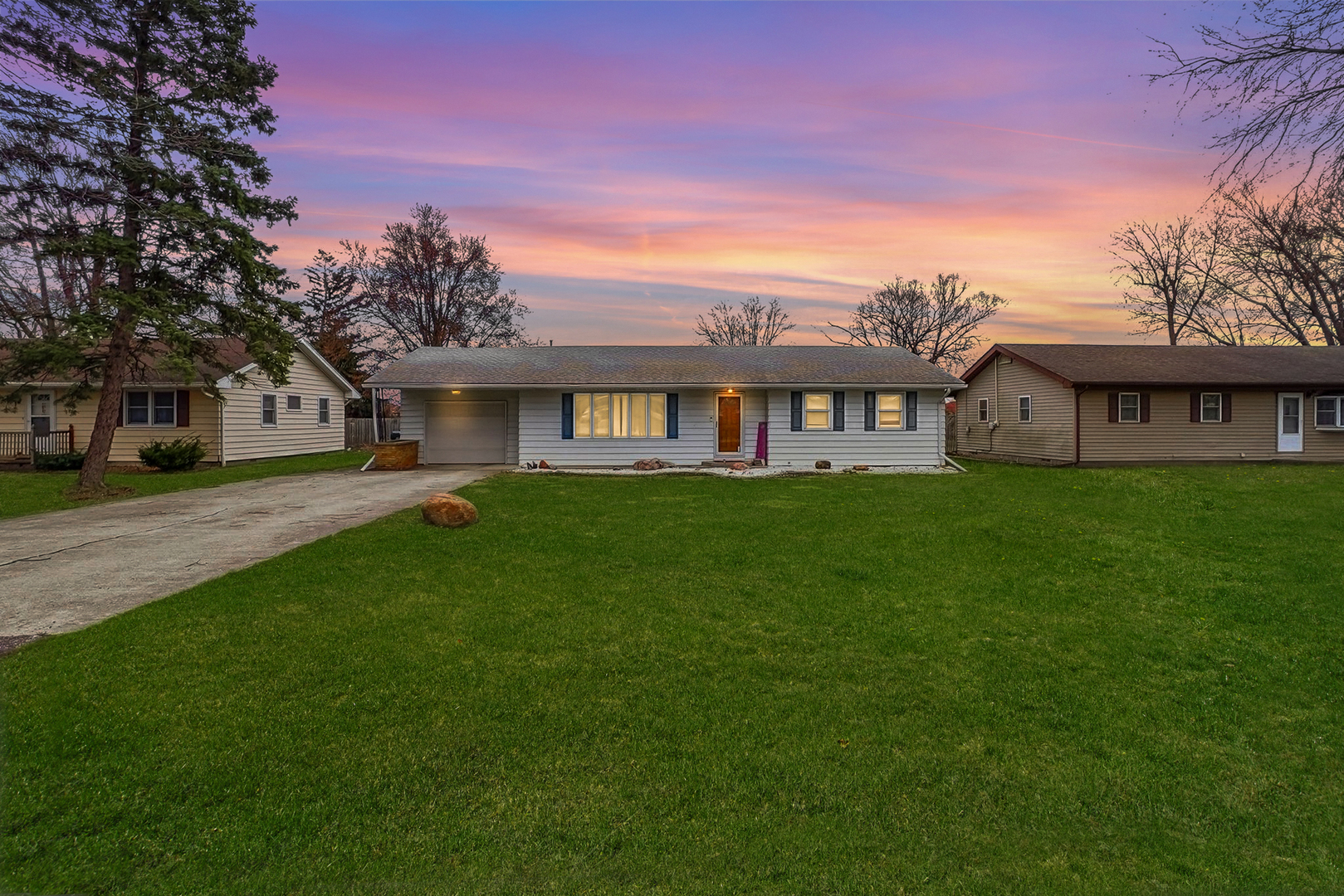 a view of a house with a big yard and large trees