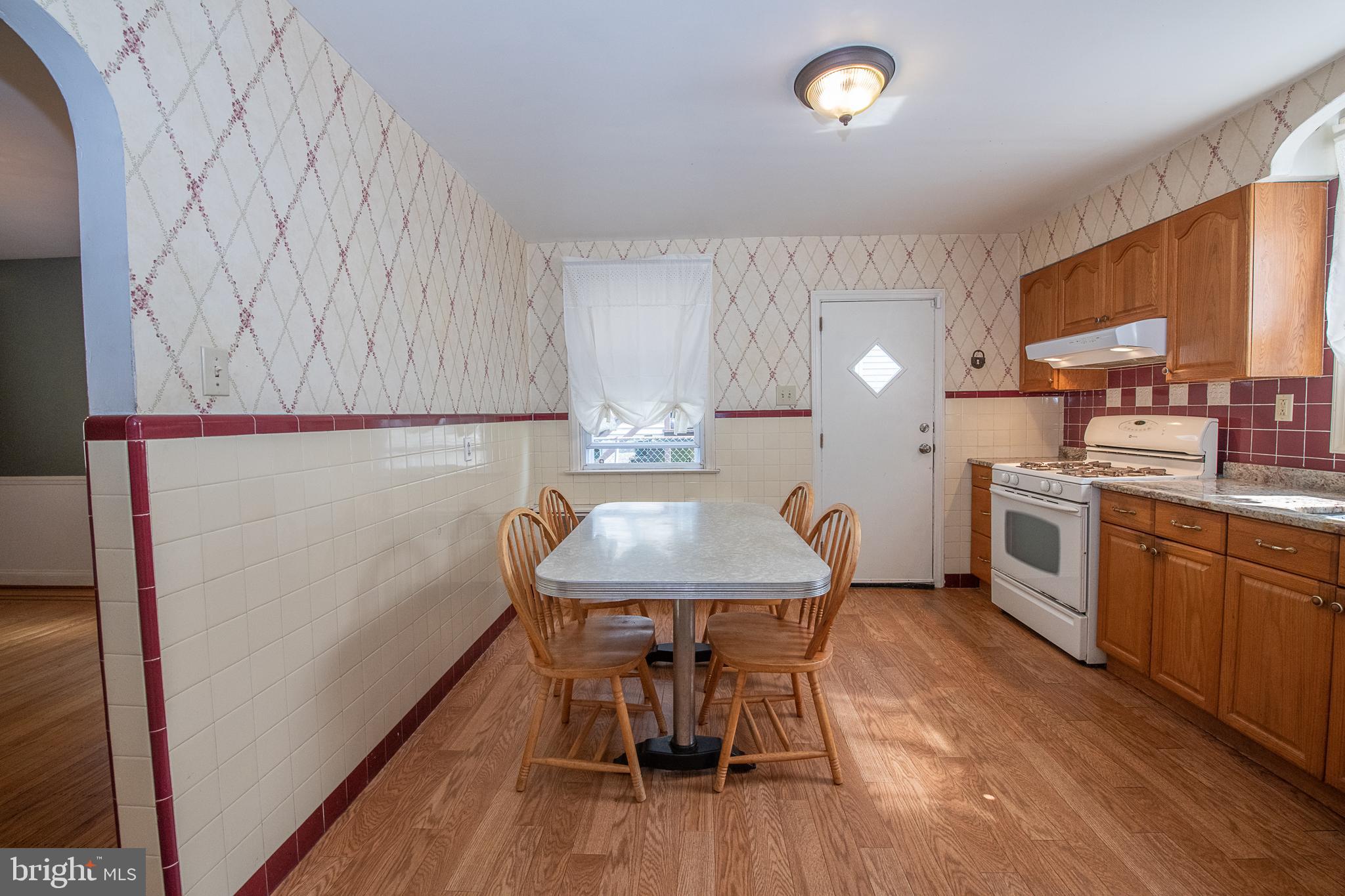 1454 Manoa Road Wynnewood, PA 19096 - Photo 11 of 41 a kitchen with stainless steel appliances a dining table chairs and a refrigerator