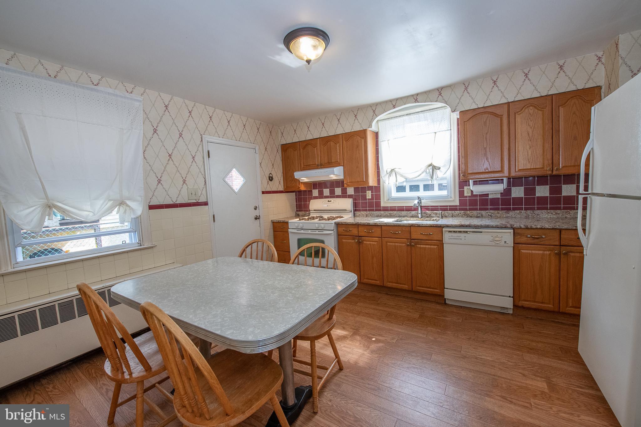 1454 Manoa Road Wynnewood, PA 19096 - Photo 9 of 41 a kitchen with a table chairs refrigerator and cabinets